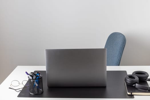 Laptop computer, notebook, and eyeglasses and headphones on a desk, place for work and study, home freelancer's office