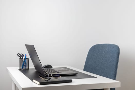 Laptop computer, notebook, and eyeglasses and headphones on a desk, place for work and study, home freelancer's office
