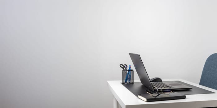 Laptop computer, notebook, and eyeglasses and headphones on a desk, place for work and study, home freelancer's office