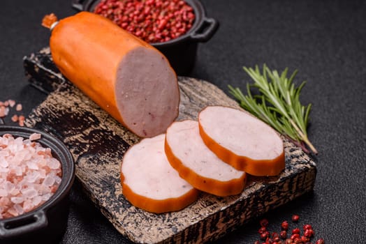 Delicious fresh ham cut into round slices with salt, spices and herbs on a dark concrete background