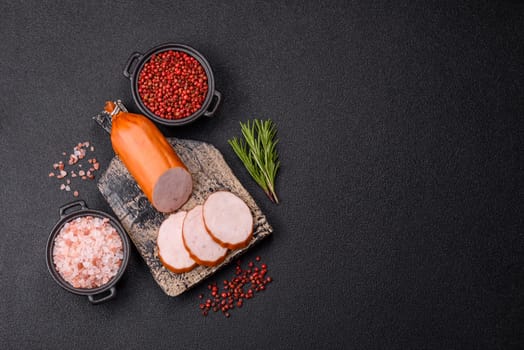 Delicious fresh ham cut into round slices with salt, spices and herbs on a dark concrete background