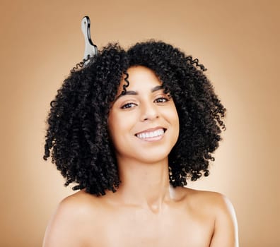 Portrait, hair care and woman with a comb, curly and salon treatment on a brown background. Face, person or model with grooming, shine or glow with volume, texture or aesthetic with keratin or smile.