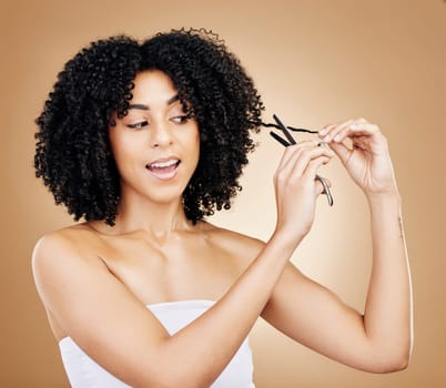 Hair, curls and scissors with woman and beauty, shine and salon treatment with natural cosmetics on studio background. Wellness, haircare and texture with tools for haircut and curly hairstyle.