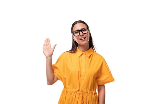 a young well-groomed woman with black straight hair dressed in a yellow dress smiles affably at the camera.