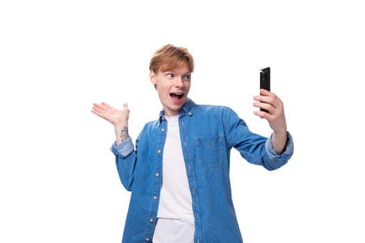 a young european guy with golden hair conducts a video broadcast on a smartphone.