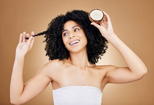 Hair, growth and coconut with woman and beauty, natural cosmetics and skin isolated on studio background. Health, oil or cream product with fruit, eco friendly for texture and shine with haircare.