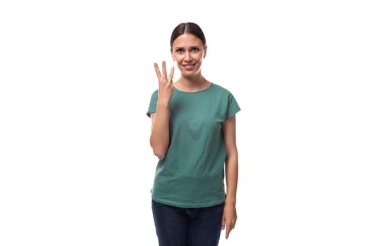 young black-haired woman in a green basic t-shirt showing 3 fingers on a white background with copy space.