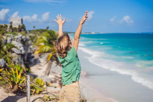 Boy tourist enjoying the view Pre-Columbian Mayan walled city of Tulum, Quintana Roo, Mexico, North America, Tulum, Mexico. El Castillo - castle the Mayan city of Tulum main temple.