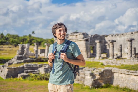 Male tourist enjoying the view Pre-Columbian Mayan walled city of Tulum, Quintana Roo, Mexico, North America, Tulum, Mexico. El Castillo - castle the Mayan city of Tulum main temple.