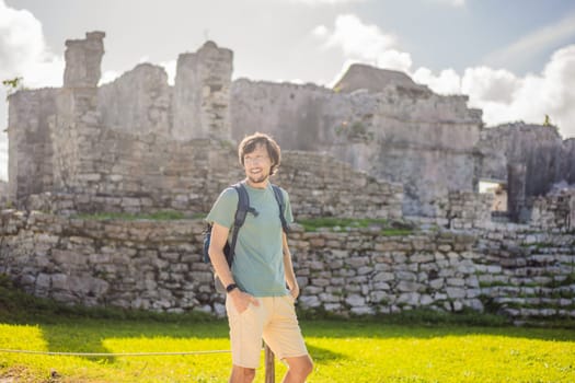 Male tourist enjoying the view Pre-Columbian Mayan walled city of Tulum, Quintana Roo, Mexico, North America, Tulum, Mexico. El Castillo - castle the Mayan city of Tulum main temple.