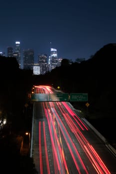 Los Angeles night exposure of red tail lights of freeway traffic toward downtown. Blue sky and red ribbon of light . High quality photo