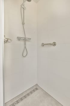 a shower with white tiles on the floor and wall behind it is an image of a hand held shower head