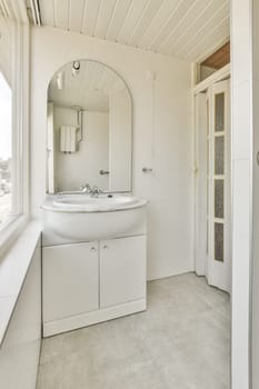 a white bathroom with a sink and mirror in the corner next to an open door that leads to a window