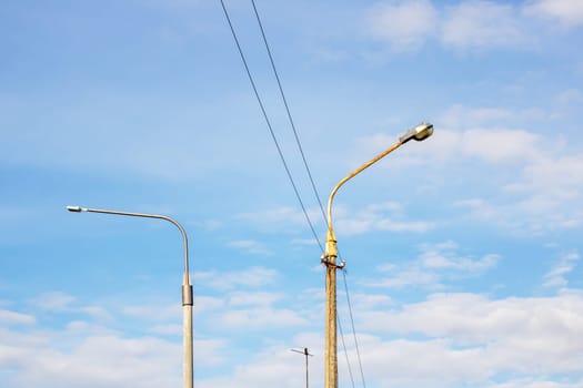 Lights and wires on blue sky background close up