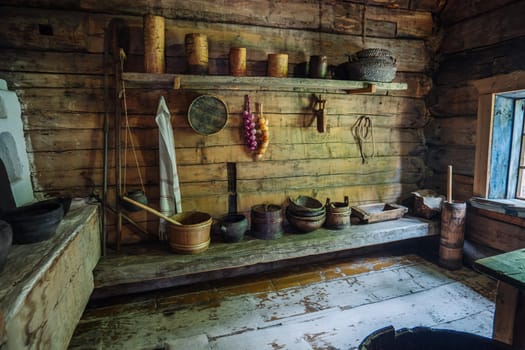 Rustic russian kitchen interior with weathered wooden surfaces, displaying vintage cooking implements, capturing traditional rural living essence