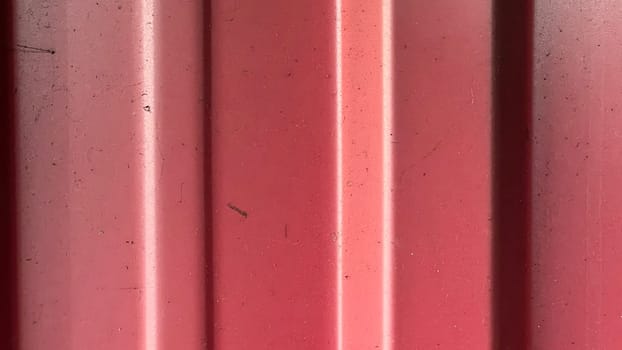A close-up view highlights the vibrant red hue and textured lines under bright light.
