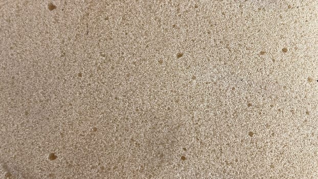 Freshly made bread dough rests on a flat surface before baking, showing its soft, airy texture.