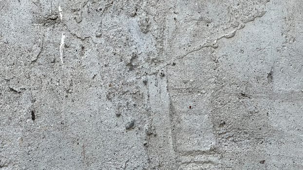A close-up view of a concrete wall featuring a rough texture and subtle patterns.
