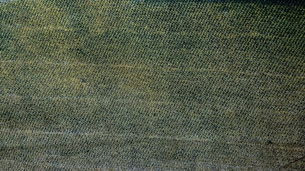 Close-up of textured fabric showcasing a blend of green and brown hues.