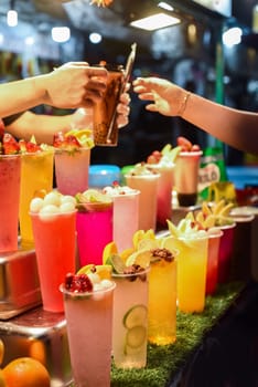 Many smoothie and drinks in plastic cups in Jalan Alor street food in the Kuala Lumpur market