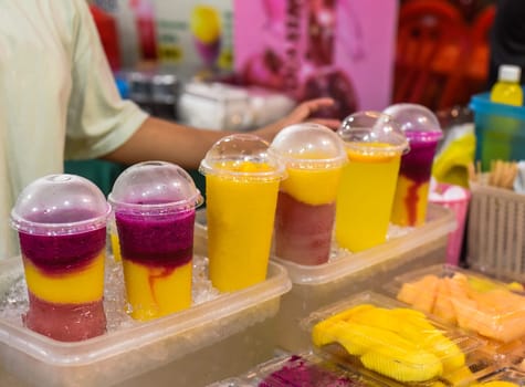 Many smoothie and drinks in plastic cups in Jalan Alor street food in the Kuala Lumpur market