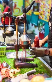Process of making pomegranate juice in Jalan Alor street food in Malaysia