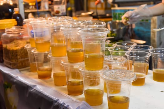 Prepared vietnamese ice tea Tra Tac with kumquat, black tea,sugar cane, without ice in street food