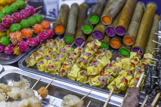 Skewers with meat and sticky rice in bamboo in vietnamese night market