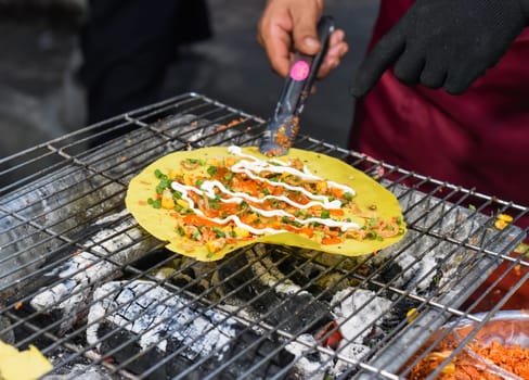 Grilled vietnamese pancake with eggs, sausages and sauces in vietnamese night market in food festival