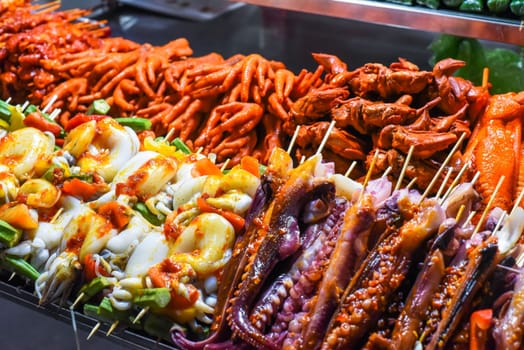 Many raw squid on skewers and seafood in vietnamese night market in Da Lat