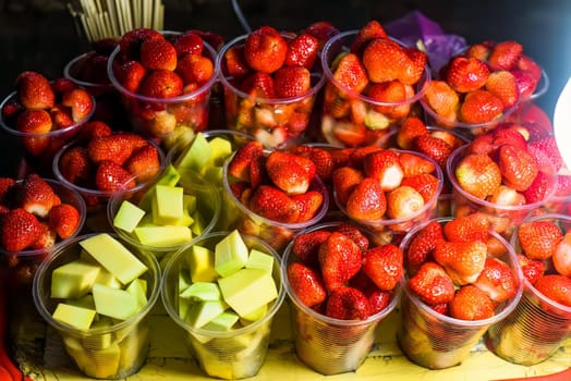 Many fresh natural strawberry and apple in vietnamese night market in Da Lat