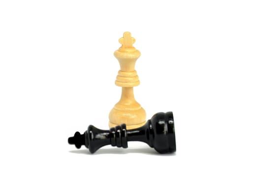 The white king defeated black king  isolated on white background. Blurred black king