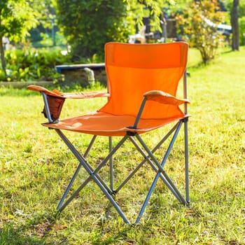 folding tourist chair standing outdoors on the grass