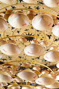 Many similar traditional Vietnamese conical hats attached to the ceiling for decoration a holiday