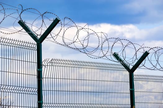Fence with barbed wire on dark blue sky background. Concept of freedom