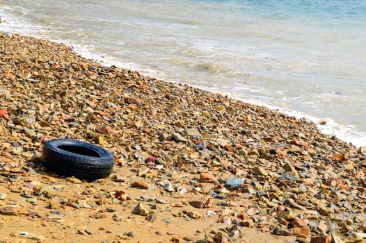 The sea washed ashore car wheel. Environmental pollution concept. copy space. Japanese sea, Russia
