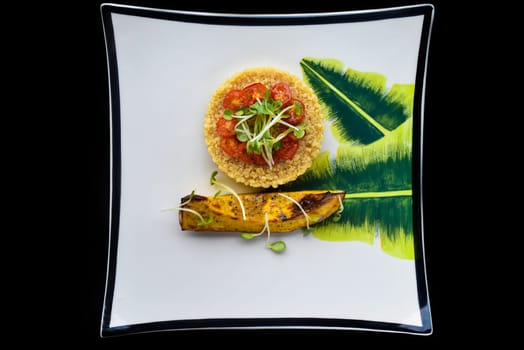 Vegetarian porridge quinoa with baked pumpkin and tomatoes isolated on black background