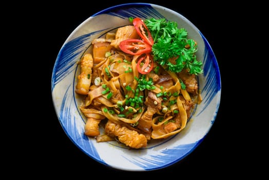 Vietnamese fried pork with noodle and ginger on black background