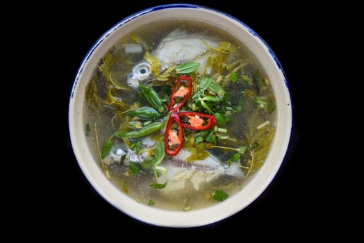 Canh Chua Ca or Vietnamese Sour Catfish Soup isolated on black background