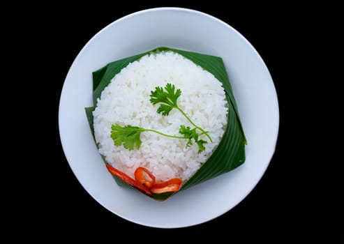 Vietnamese white rice in banana leaf isolated on black background for a menu