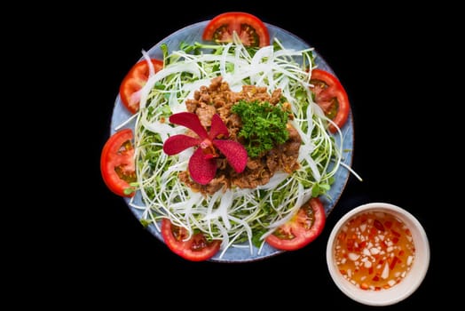Vietnamese fried beef with salad and sauce on black background for a menu