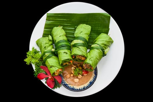 Vietnamese green nem spring rolls in leaf with sauce