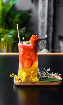 Fresh summer drink with strawberry jam and orange juice isolated on black background