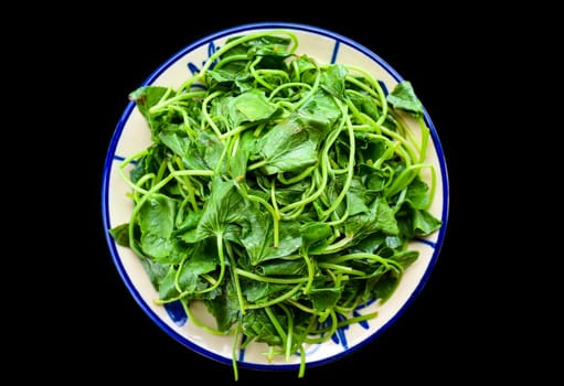 Vietnamese fried sweet potato leaves with garlic on black background