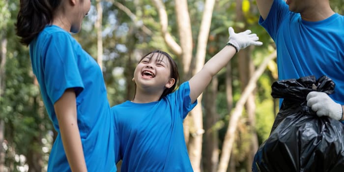 A cheerful family of volunteers celebrates their successful cleanup in a park, highlighting joy and commitment to the environment.