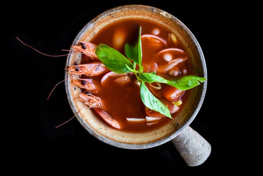 Soup tom yum with rice isolated on black background side view