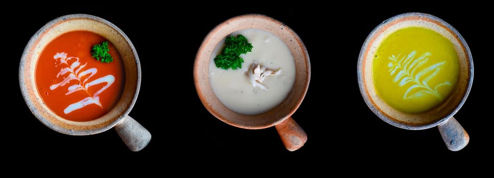 Tomato, pumpkin and mushroom cream soups vegetarian on black background
