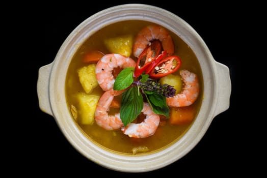 Stew with shrimps and pineapple  isolated on black background top view