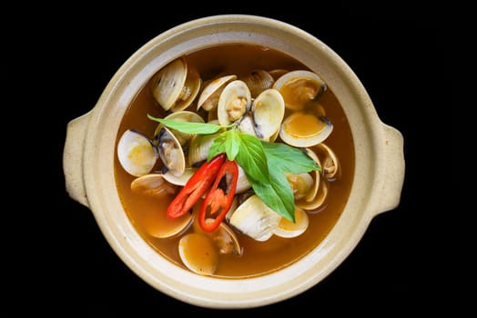 Steamed clams or clam soup cooked in vietnamese style isolated on black background top view
