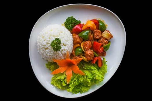 Stewed beef with vegetables and rice isolated on black background top view